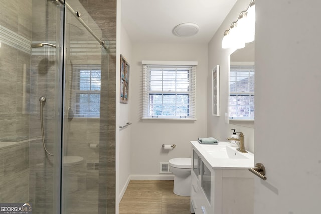 bathroom with toilet, a shower stall, visible vents, and baseboards