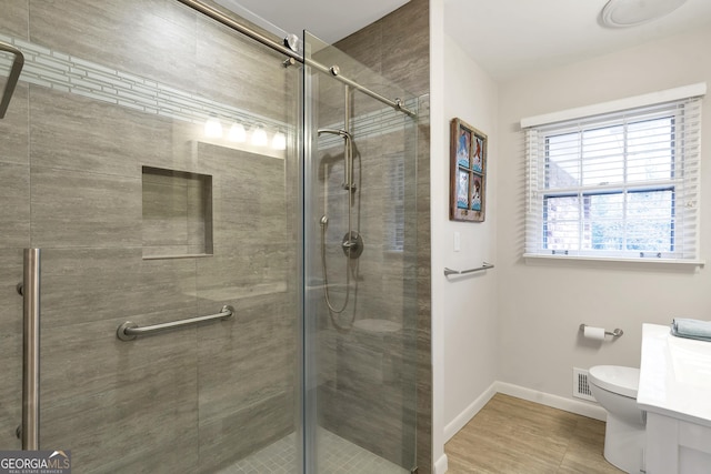 bathroom featuring visible vents, baseboards, a shower stall, and toilet