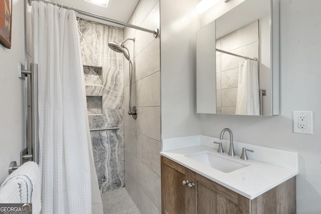 bathroom featuring a tile shower and vanity