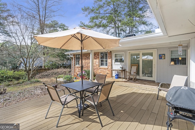 deck featuring outdoor dining space and a grill