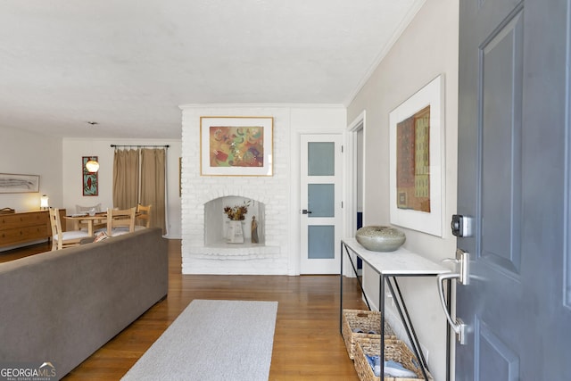 entrance foyer with wood finished floors and crown molding