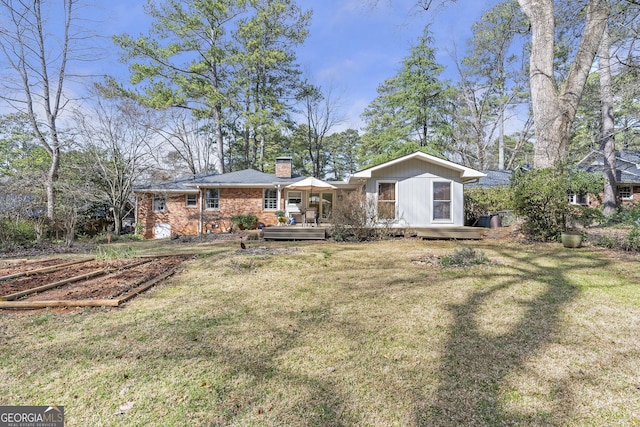 back of house with a yard, a chimney, and a wooden deck