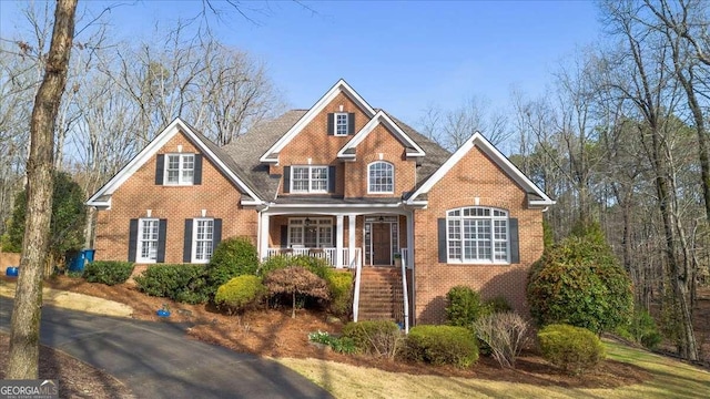 view of front of property featuring covered porch and brick siding