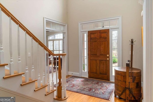 foyer entrance featuring stairway and wood finished floors