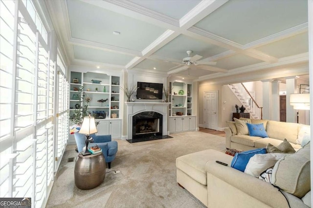 living area with beam ceiling, coffered ceiling, a fireplace, and stairway