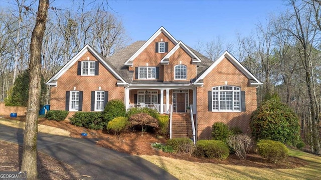 view of front facade with covered porch and brick siding