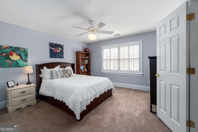 carpeted bedroom featuring visible vents, baseboards, and a ceiling fan