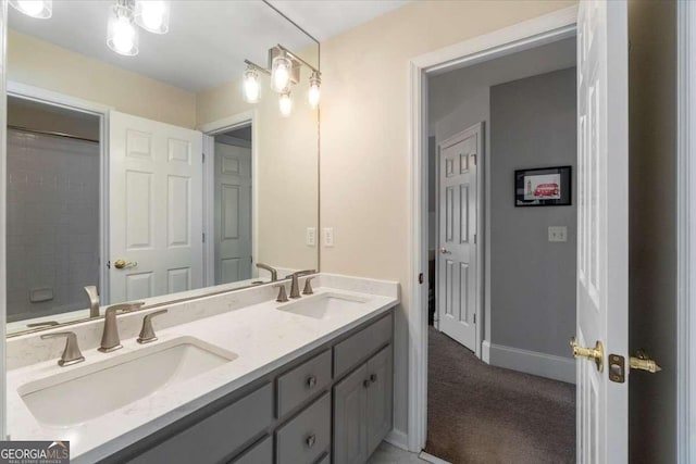 bathroom featuring double vanity, a sink, and baseboards