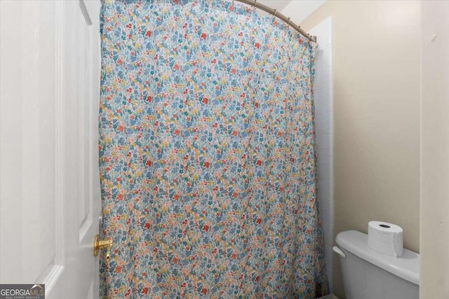 full bathroom with a shower with curtain and toilet