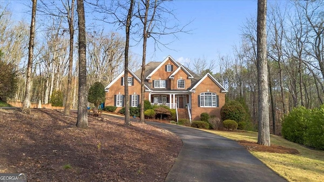 traditional home with driveway and brick siding