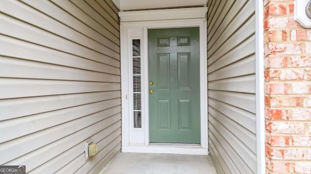 property entrance featuring brick siding