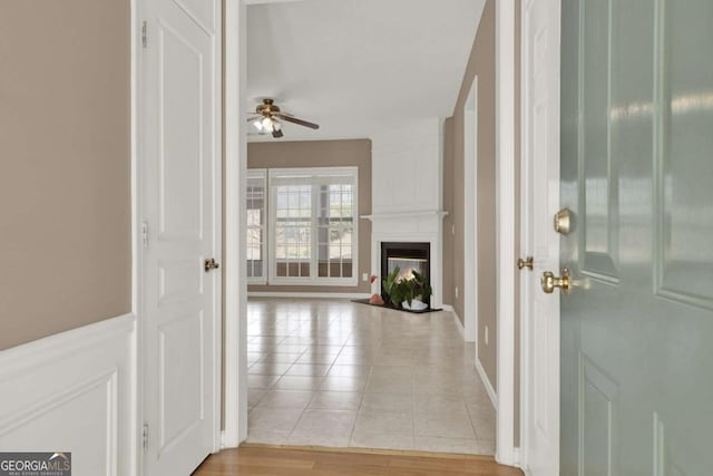 entrance foyer featuring a ceiling fan, light tile patterned flooring, and a fireplace