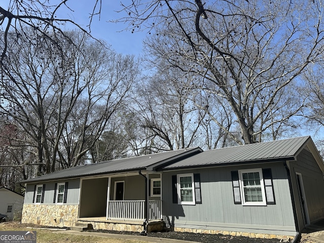 ranch-style home featuring metal roof and a porch