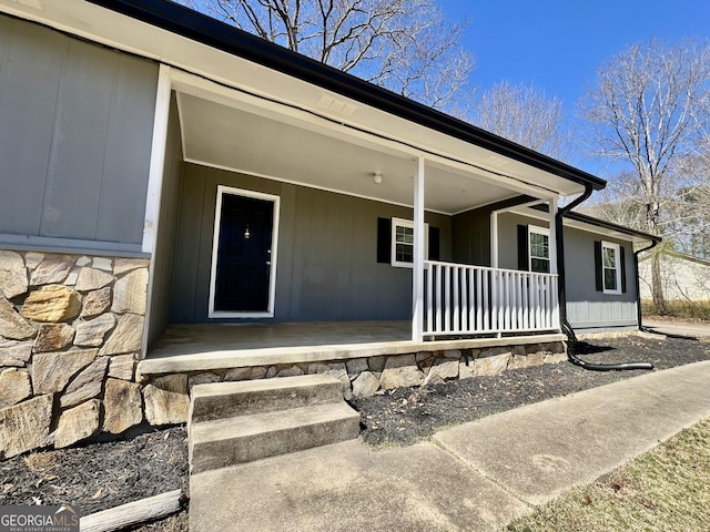 entrance to property featuring stone siding and covered porch