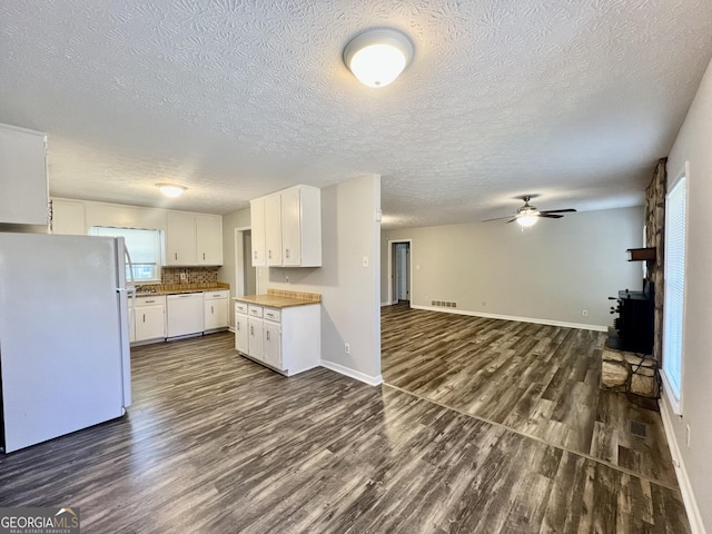 kitchen featuring visible vents, dark wood-style floors, open floor plan, white appliances, and white cabinets