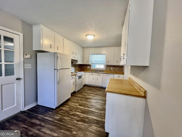 kitchen featuring tasteful backsplash, a sink, white cabinets, white appliances, and dark wood-style flooring