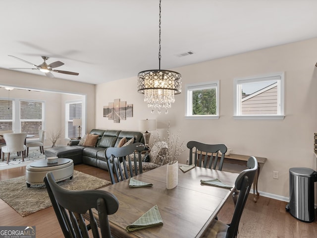 608 Larch Looper Dr, Griffin, GA 30223 - dining area with visible vents, baseboards, wood finished floors, and ceiling fan with notable chandelier