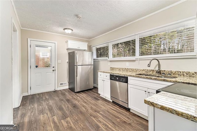 kitchen featuring visible vents, dark wood finished floors, stainless steel appliances, white cabinetry, and a sink