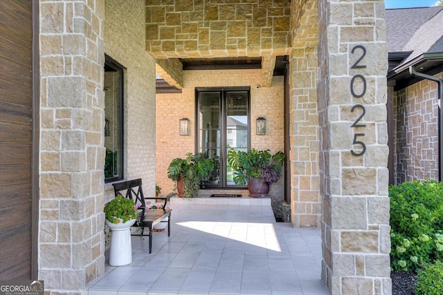 view of exterior entry with stone siding and brick siding