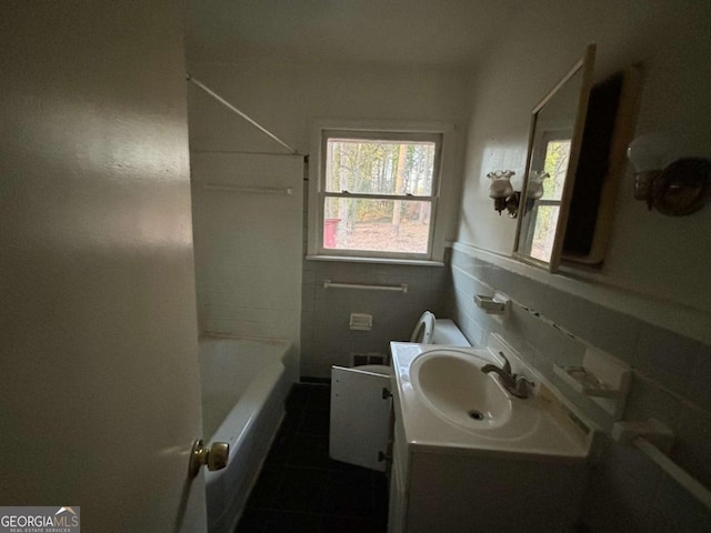 full bath featuring toilet, a wainscoted wall, tile walls, and vanity