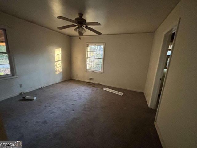 carpeted spare room featuring a ceiling fan