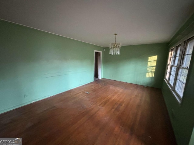 unfurnished dining area featuring wood finished floors and a notable chandelier