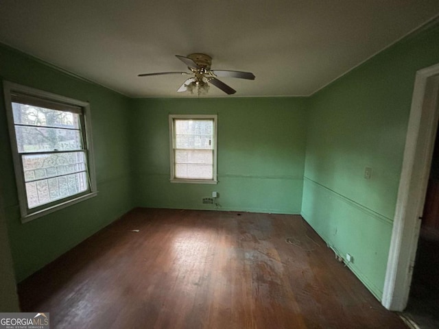 spare room featuring a ceiling fan, a healthy amount of sunlight, and wood finished floors