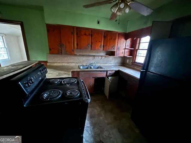 kitchen featuring black appliances, a wealth of natural light, light countertops, and a sink