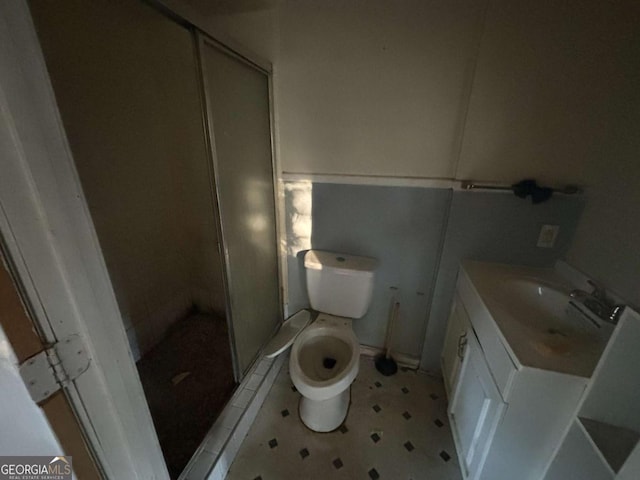 full bathroom featuring a stall shower, vanity, and toilet