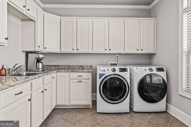 washroom with cabinet space, ornamental molding, tile patterned flooring, washing machine and dryer, and a sink