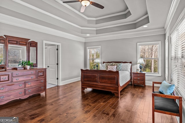 bedroom with dark wood-type flooring, a ceiling fan, baseboards, ornamental molding, and a raised ceiling