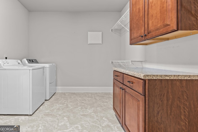 laundry area with washing machine and dryer, cabinet space, and baseboards