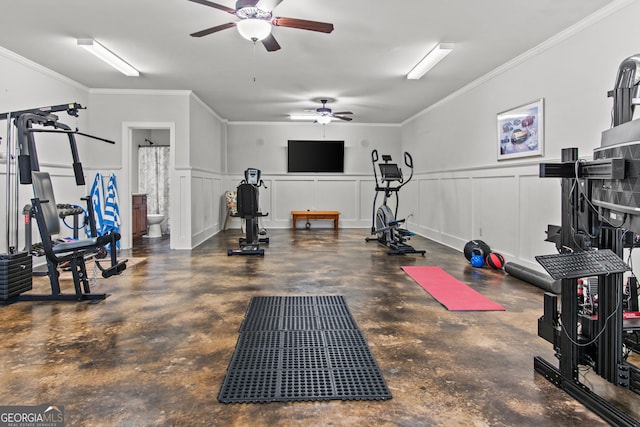 workout room with crown molding, wainscoting, a decorative wall, and ceiling fan