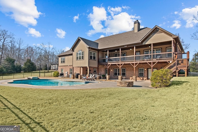 rear view of house with a yard, an outdoor fire pit, brick siding, and a patio