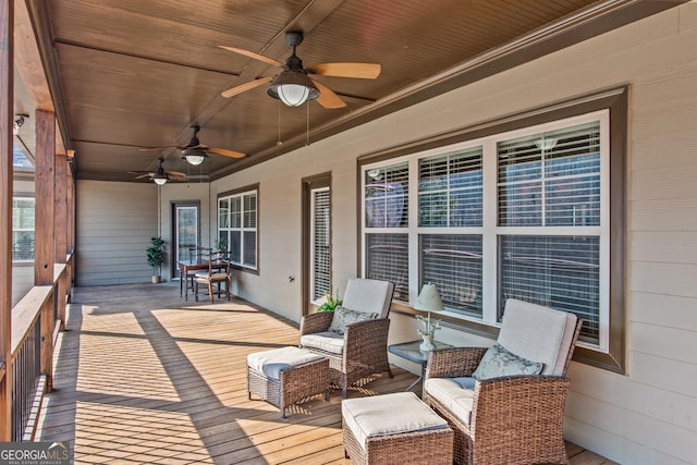 wooden deck featuring covered porch and ceiling fan