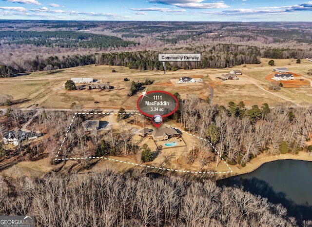 drone / aerial view with a water view and a view of trees