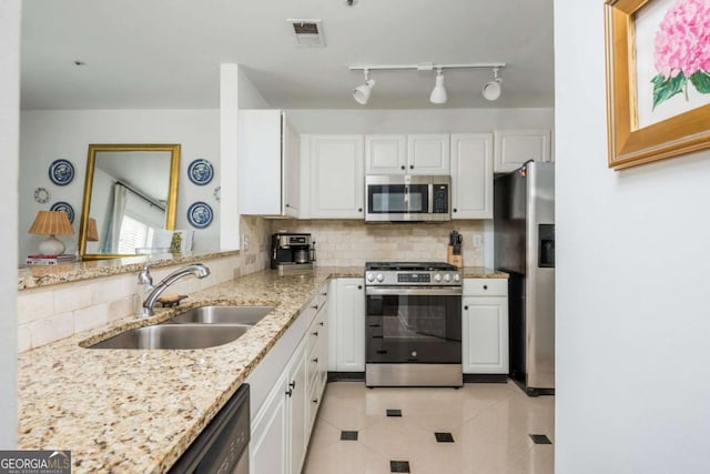 kitchen with appliances with stainless steel finishes, visible vents, a sink, and white cabinetry