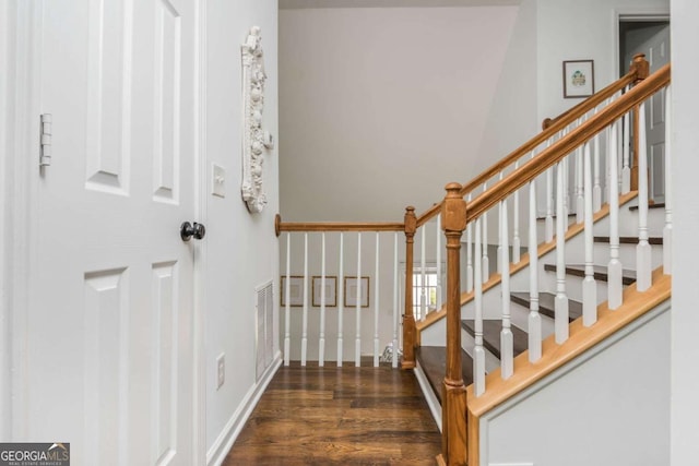 stairs featuring wood finished floors, visible vents, and baseboards