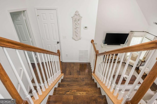 stairway with baseboards, visible vents, and wood finished floors