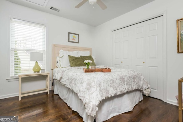 bedroom featuring a closet, dark wood finished floors, visible vents, and baseboards