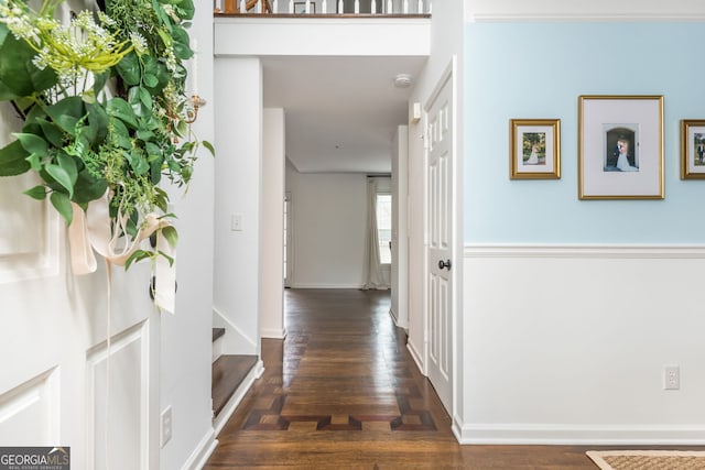 corridor with wood finished floors and baseboards