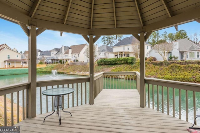 wooden terrace featuring a residential view, a water view, and a gazebo