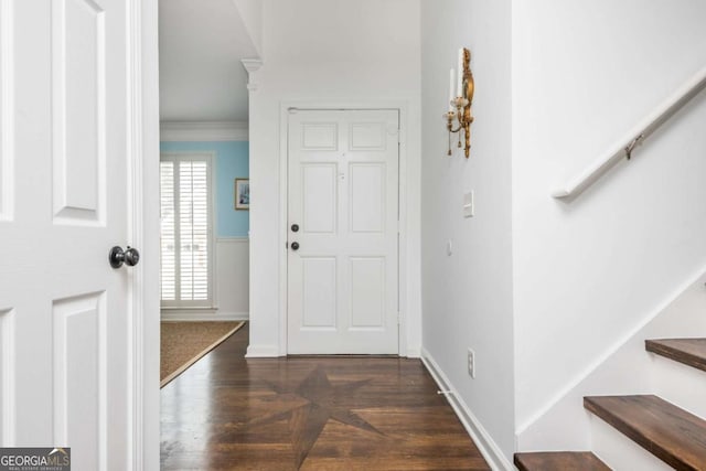 foyer entrance featuring stairs, baseboards, dark wood-style flooring, and crown molding