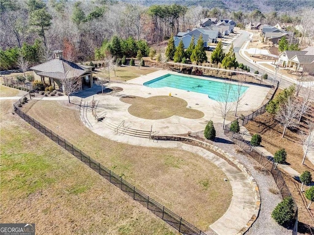 community pool with a patio area and fence