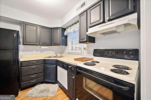 kitchen with visible vents, dishwasher, electric range oven, freestanding refrigerator, and under cabinet range hood