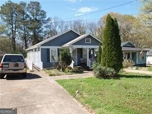 bungalow-style home featuring driveway and a front lawn