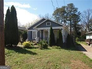 bungalow featuring driveway and a front lawn