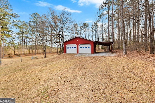 garage featuring a detached garage, fence, and driveway