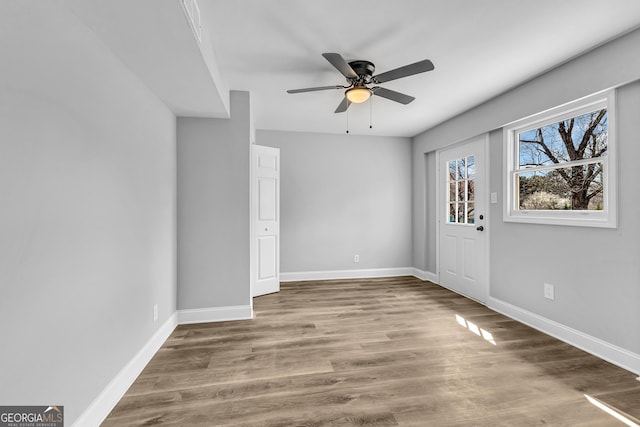 foyer featuring a ceiling fan, baseboards, and wood finished floors