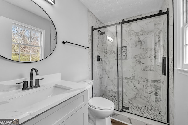 full bath featuring toilet, a marble finish shower, and vanity